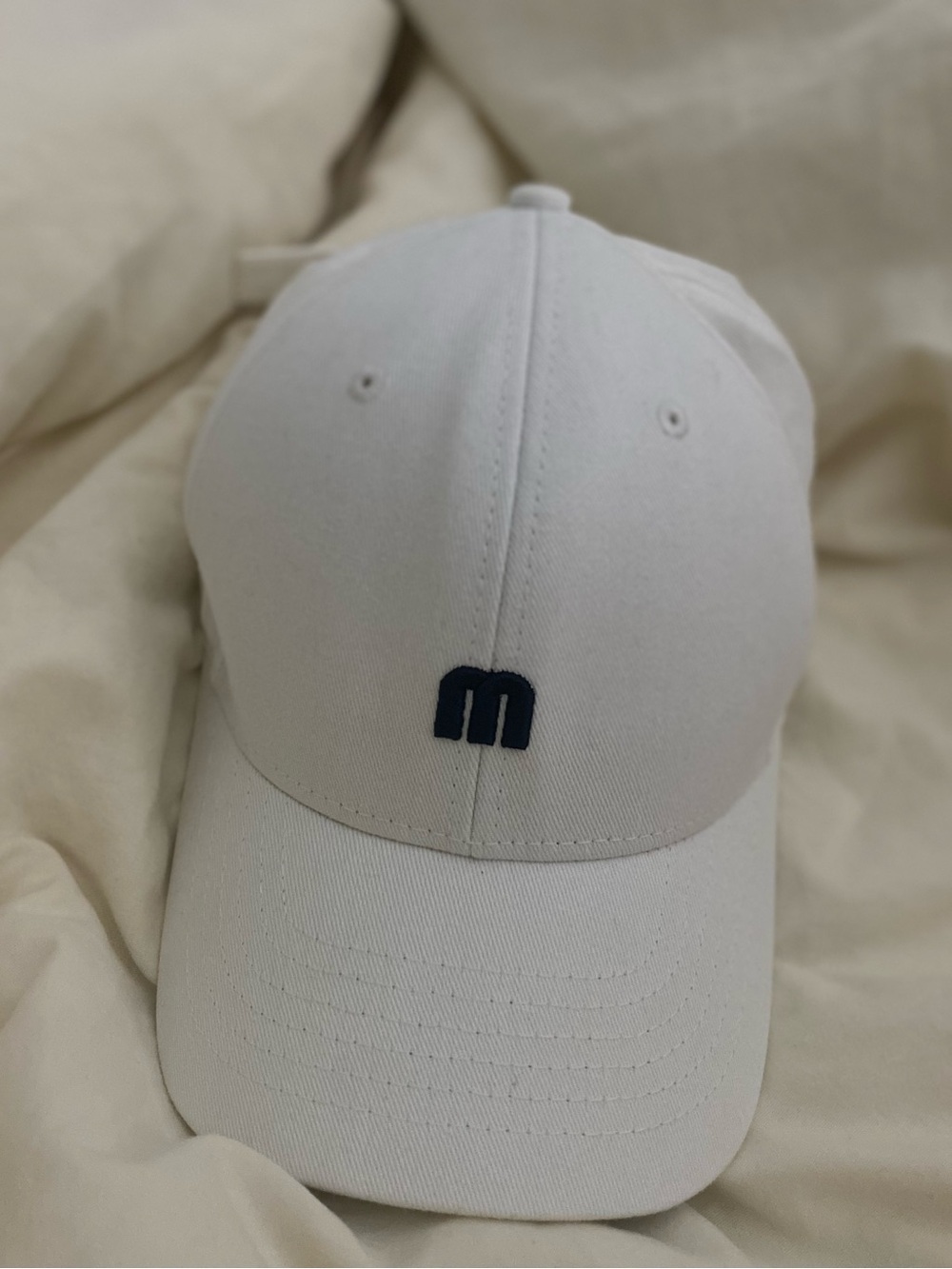 White Baseball Cap with Navy 'M' Logo